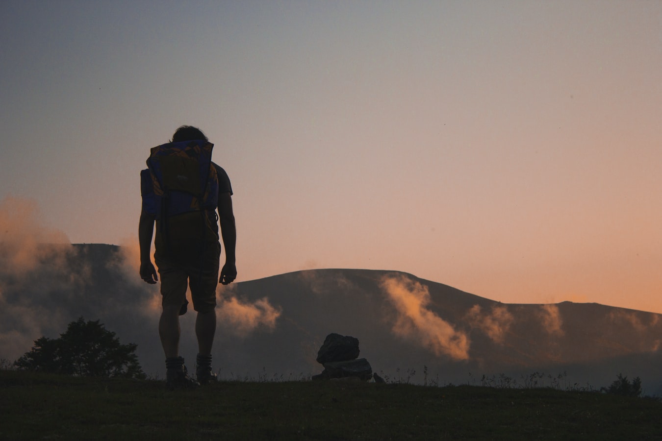 man with backpack looking ahead into the unknown